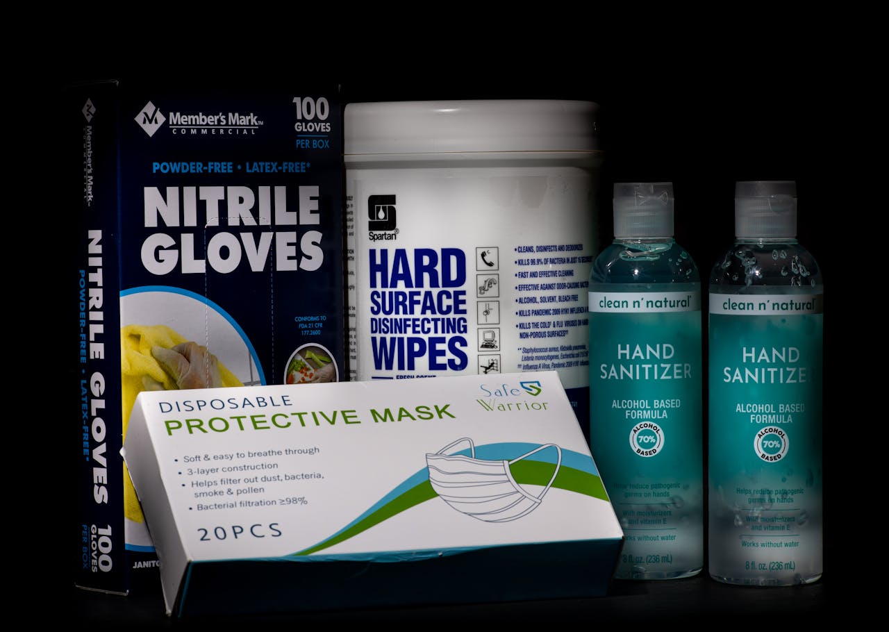 Front view of essential COVID-19 safety supplies including gloves, masks, wipes, and sanitizers.
